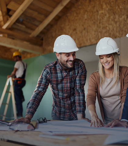 Architects reviewing blueprints on construction site.