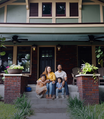 Family sitting on steps of their home.